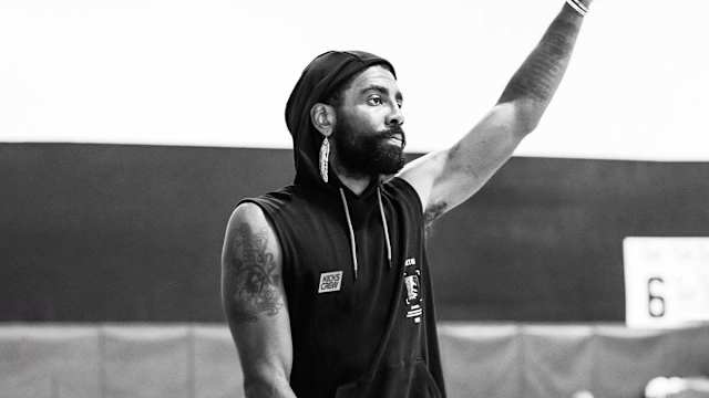 Kyrie Irving waves in a photo shoot.